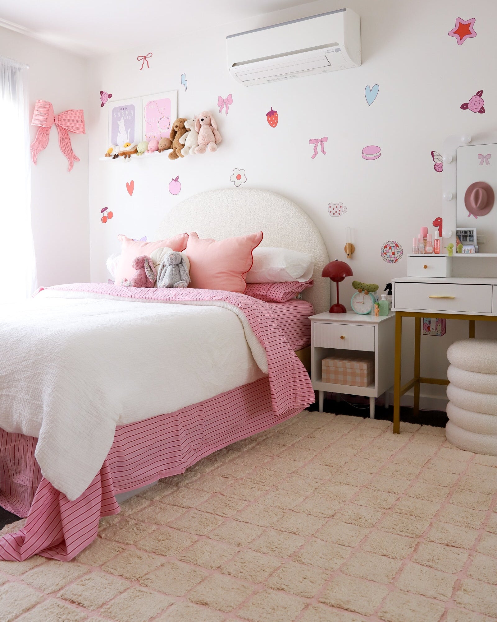 Children's bedroom with pink and white decor, including a bed, desk, and wall stickers.