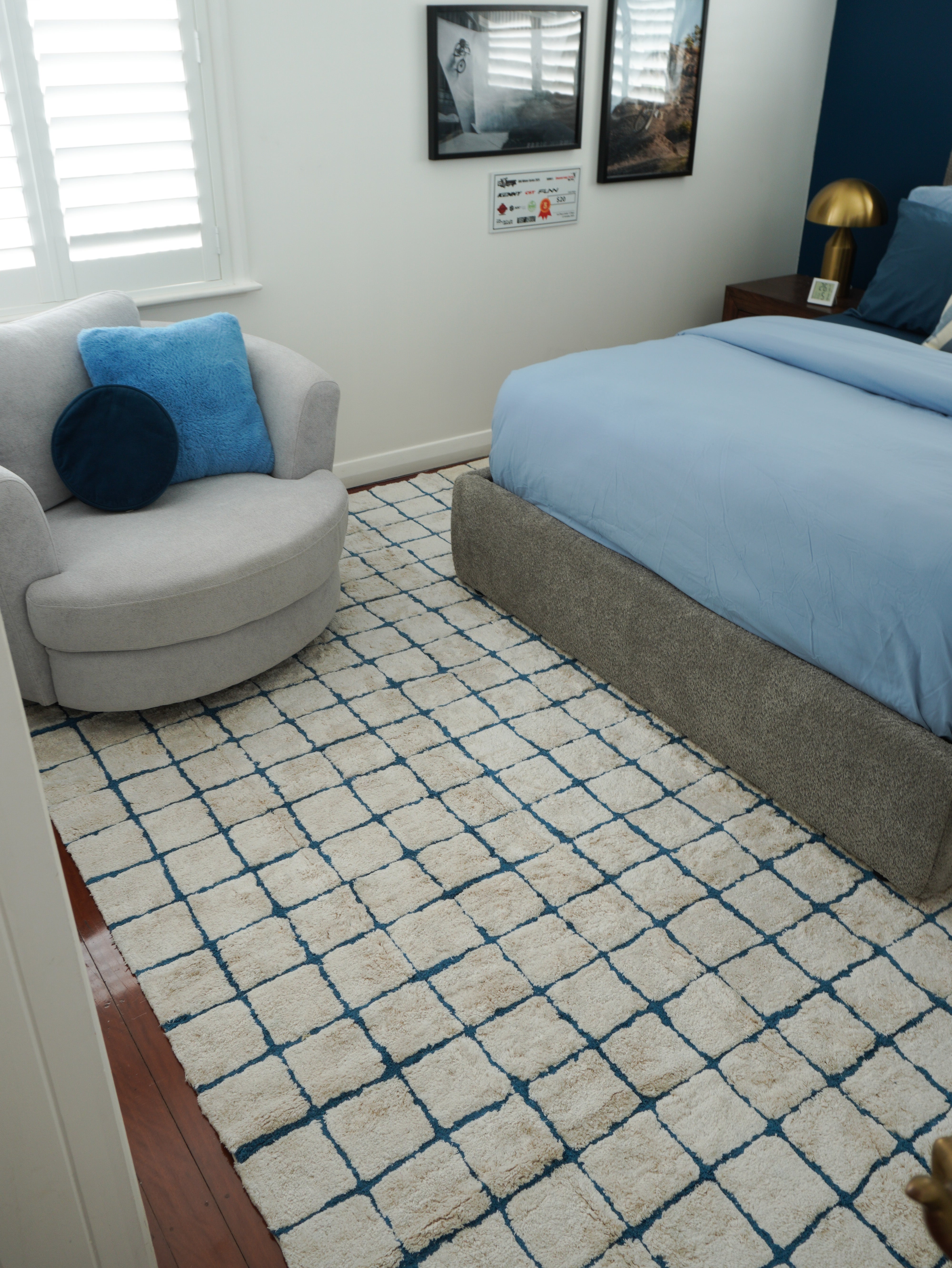 Bedroom with a patterned rug, bed, and sofa.