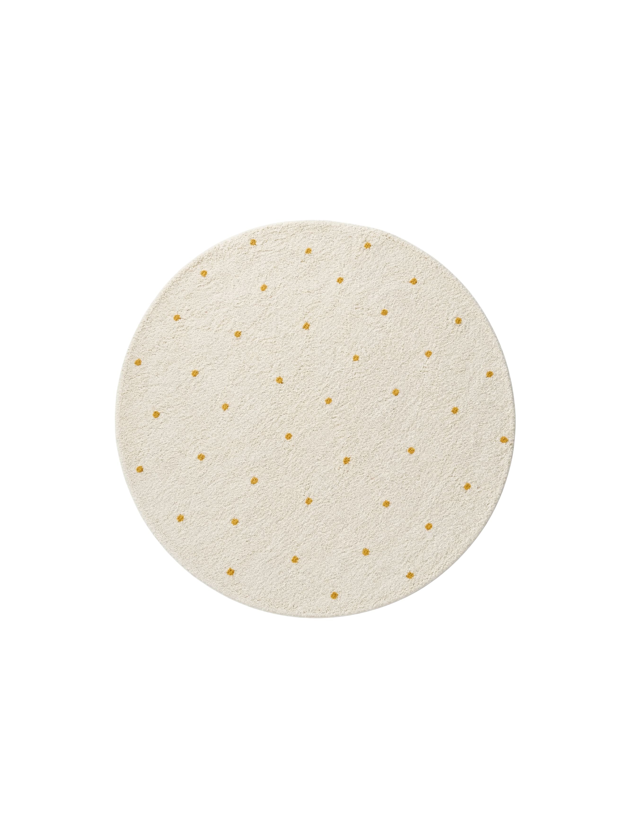 Round beige rug with small yellow dots on a white background